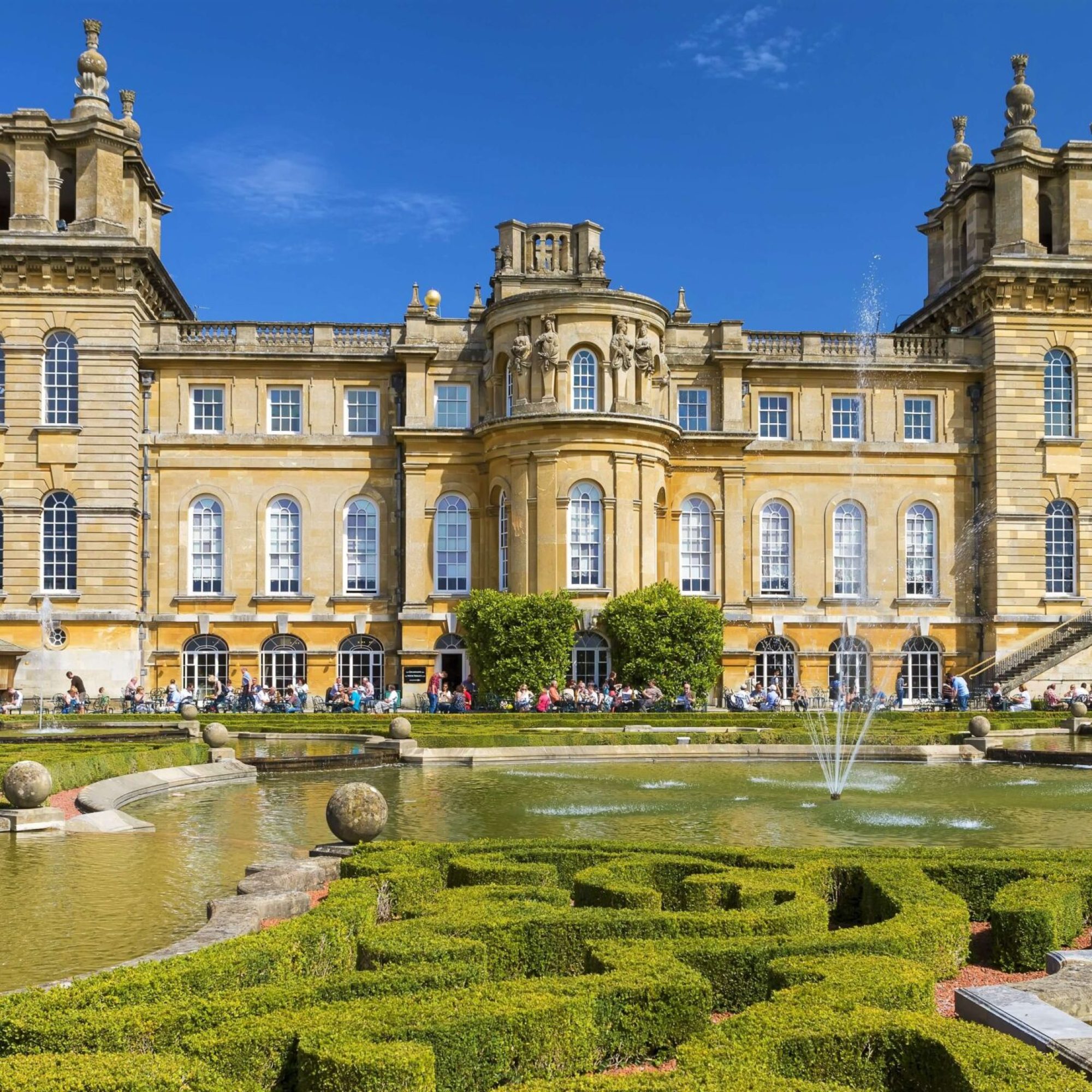 Blenheim Palace. Honey coloured Cotswold stone and lush green gardens.
