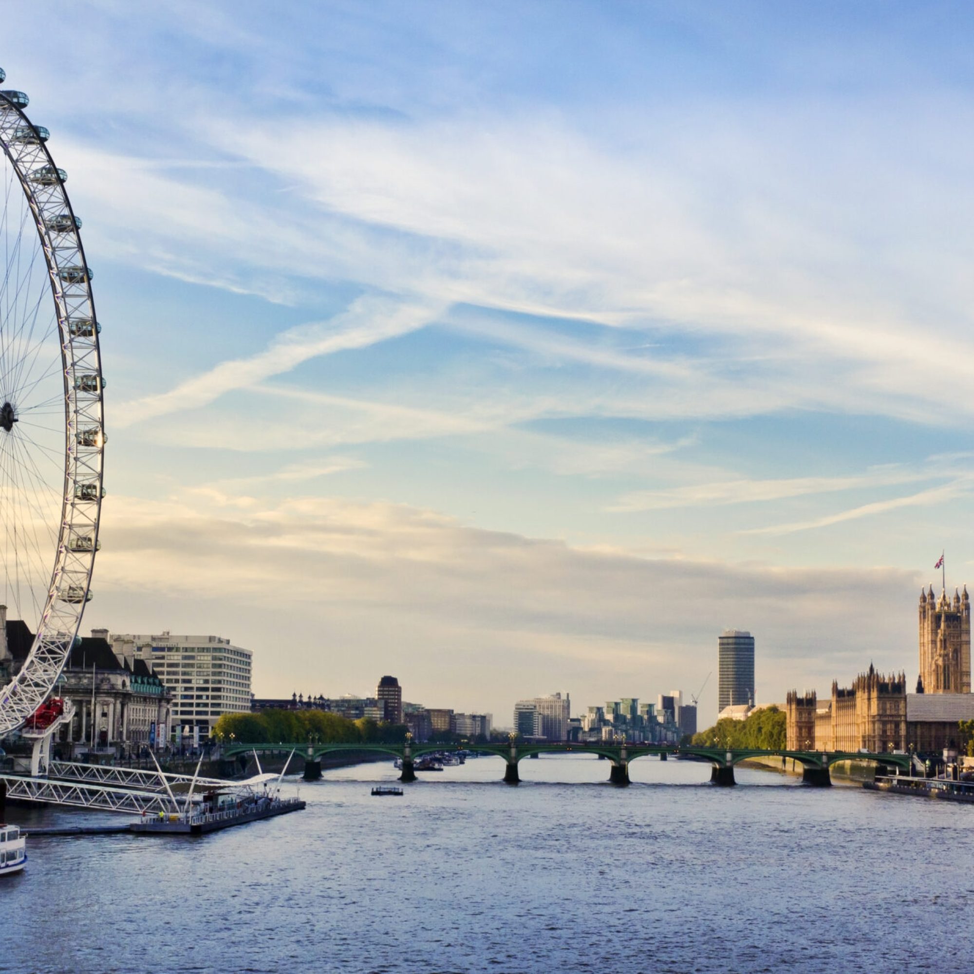 Beginning of a sunset and view of the London Eye. Blue and yellow sky with soft clouds